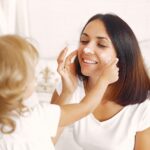 Mom applying moisturizer as part of her daily skincare routine