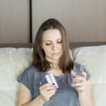 a woman sitting on a couch looking at her cell phone